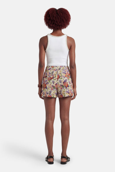 Short multicolore de COLOURFUL REBEL, avec imprimé floral et porté avec un haut blanc à détails strass et des sandales.