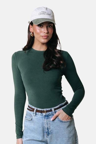 Groene T-shirt met lange mouwen van COLOURFUL REBEL, gedragen met spijkerbroek en een pet.
