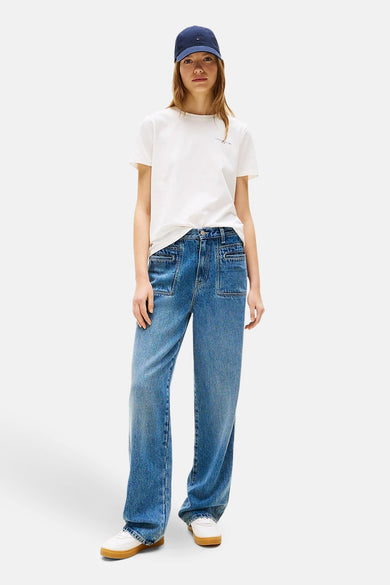 T-shirt blanc à manches courtes de Tommy Hilfiger, porté avec des jeans droits et un chapeau bleu.