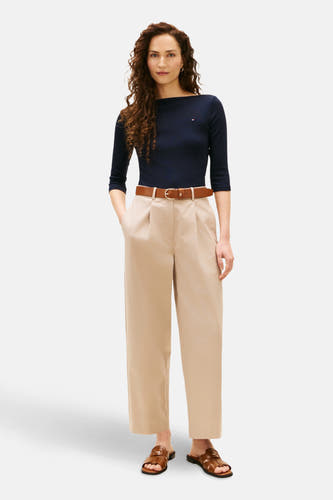 T-shirt bleu marine à manches courtes de TOMMY JEANS, associé à une ceinture brune et un pantalon beige.