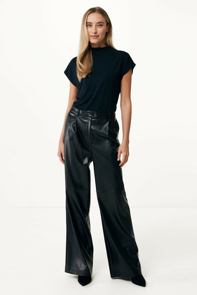 Blouse noire à manches courtes de MEXX, design minimaliste avec col montant, portée avec un pantalon en cuir noir et des escarpins, vue de face.