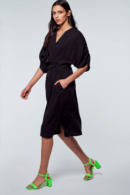 Robe longue noire de YŪGEN, avec ceinture, manches courtes et sandales vertes à talons.
