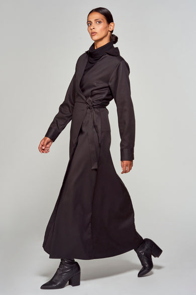 Robe noire à longues manches de YŪGEN, portée avec un gilet noir et des bottines en cuir.