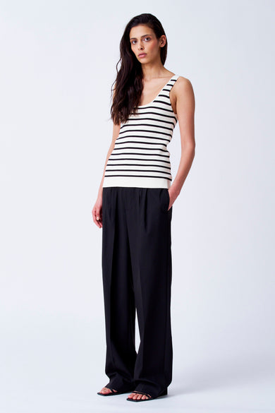 T-shirt beige de YŪGEN, avec des rayures noires et porté avec un pantalon noir.