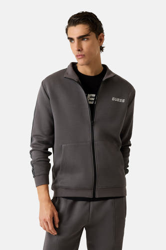 Grijs vest van Guess met ritssluiting en lange mouwen, gedragen over een zwart T-shirt.