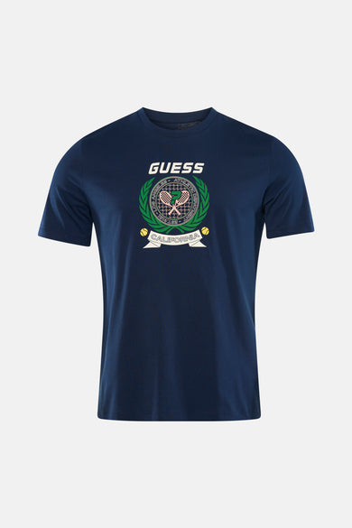 T-shirt bleu à manches courtes de Guess, avec imprimé logo et porté avec un jean et des baskets.