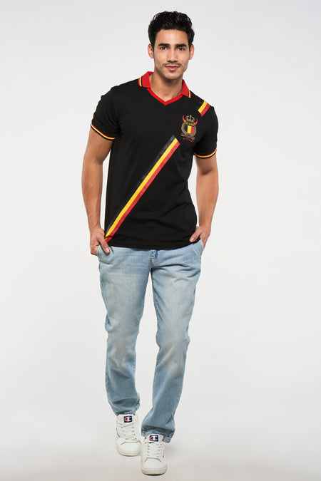Zwart T-shirt met korte mouwen van ZEB STYLE LAB, met België badge en Belgische driekleurige strepen. Lichtblauwe jeans en witte Champion schoenen.