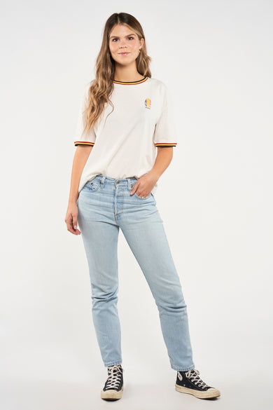 T-shirt blanc à manches courtes de ZEB STYLE LAB, finition avec des bordures colorées et porté avec un jean et des baskets noires.